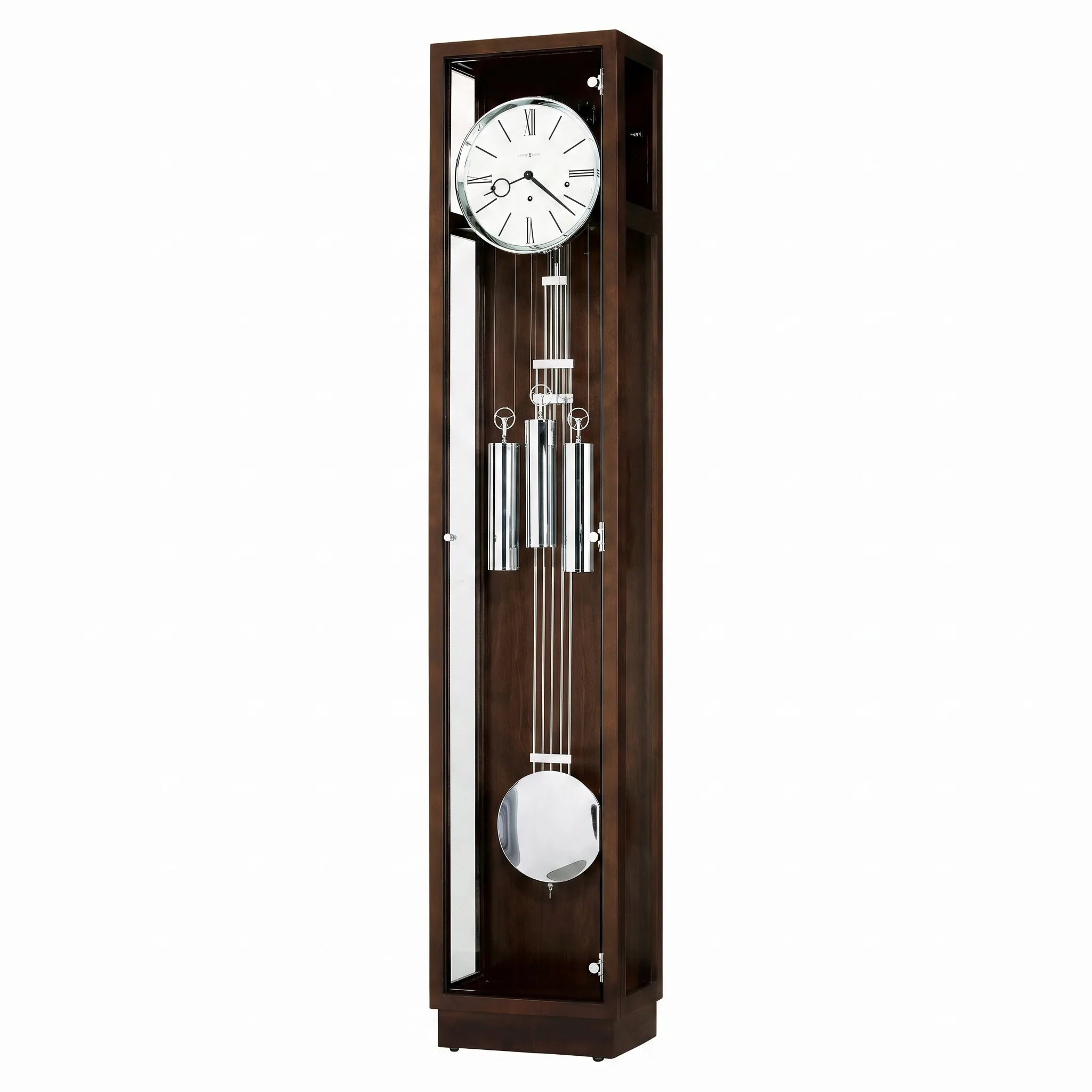 A tall, rectangular wooden grandfather clock with a dark brown finish, featuring a white clock face with black Roman numerals, a silver-toned pendulum, and a polished metal weight at the bottom, shown against a plain white background.