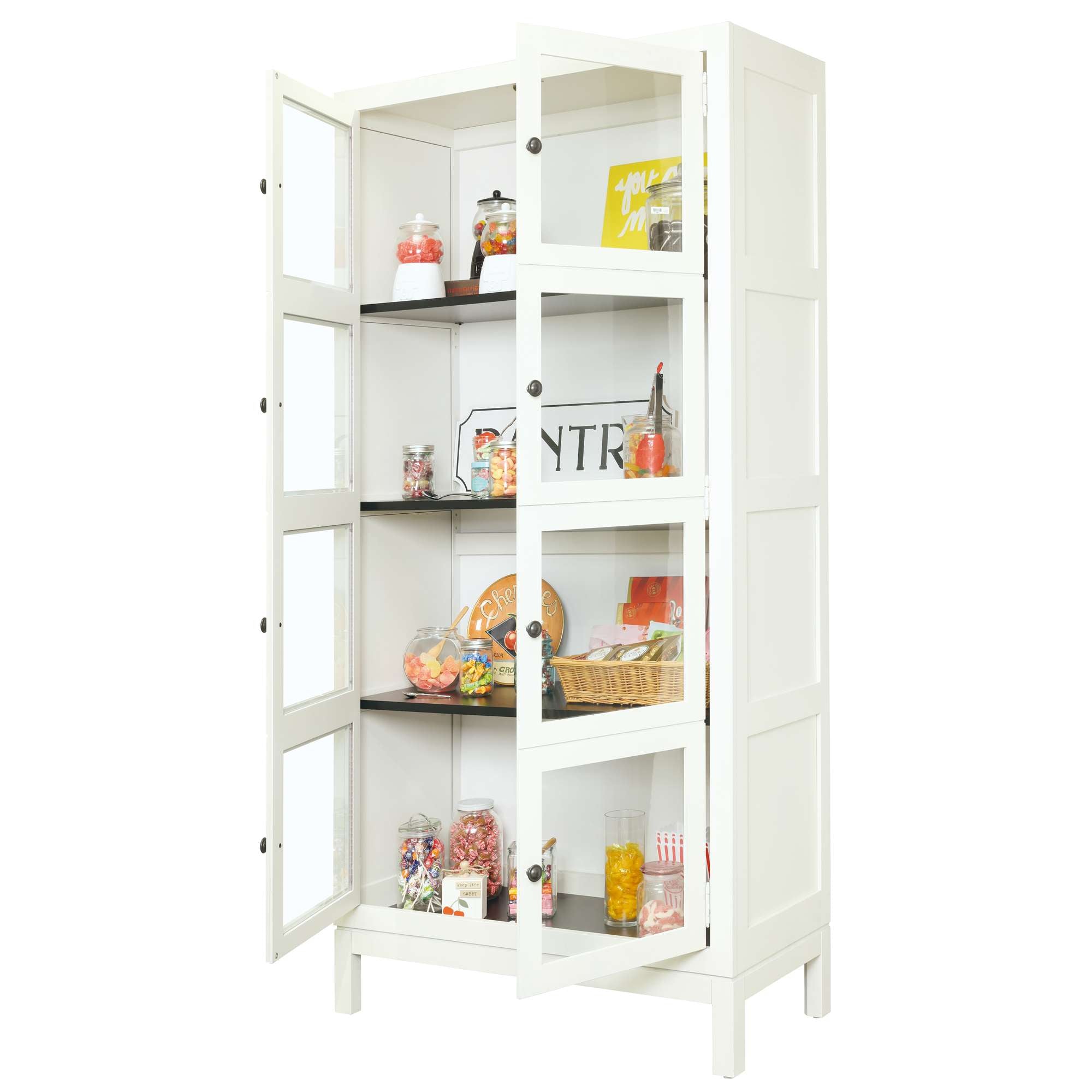 White pantry cabinet displaying various jars of candy and snacks.
