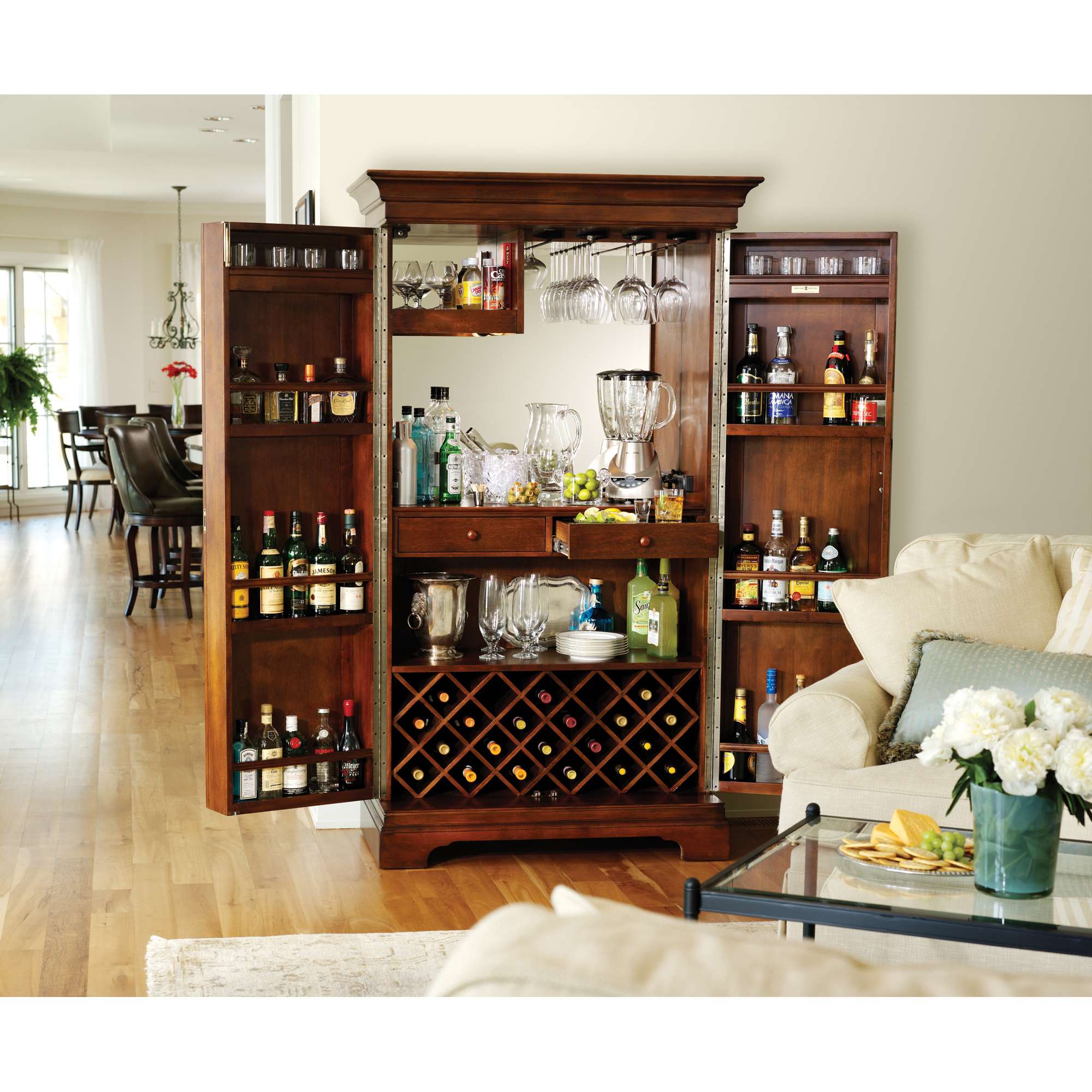 A wooden bar cabinet stocked with various bottles and glassware in a modern living space.