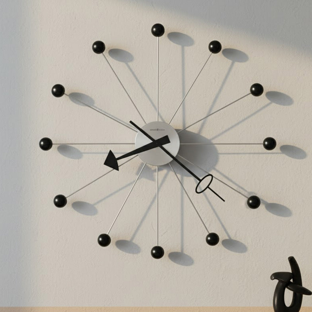 Modern wall clock with black balls, silver hands, and sleek design, perfect for contemporary decor.