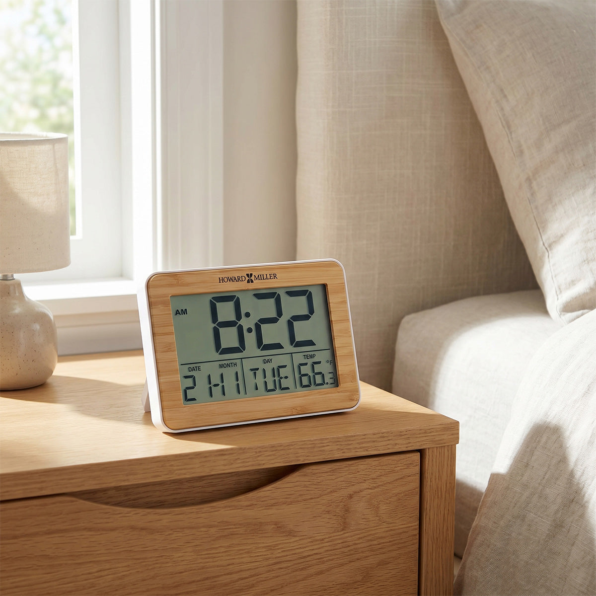 Digital bamboo alarm clock on a wooden nightstand in a bedroom setting