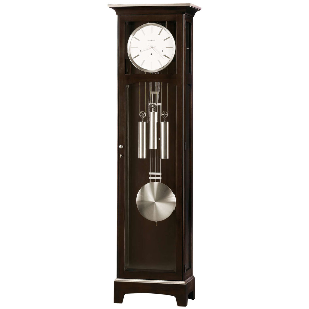 A tall, dark wood grandfather clock with a white clock face and pendulum.