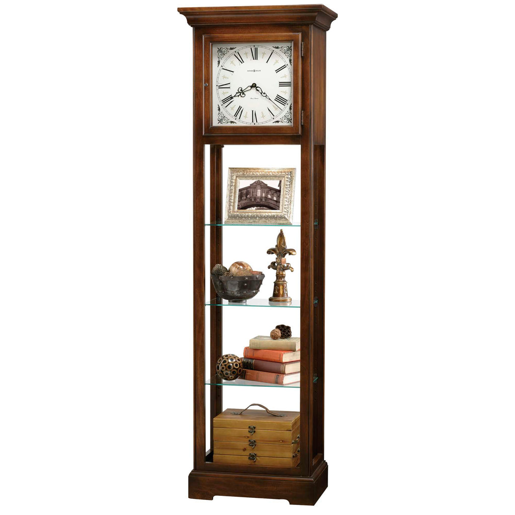 A tall wooden display cabinet featuring a clock at the top and decorative items on glass shelves.