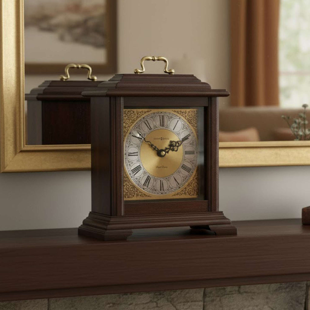 A wooden mantel clock with a decorative face, placed on a shelf in a cozy room.