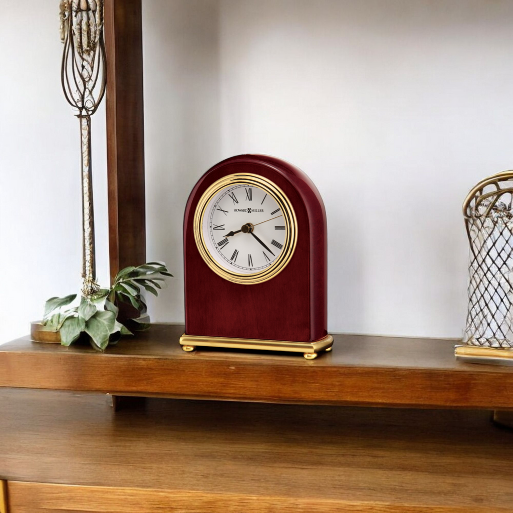 A vintage-style clock on a wooden shelf with decorative items.