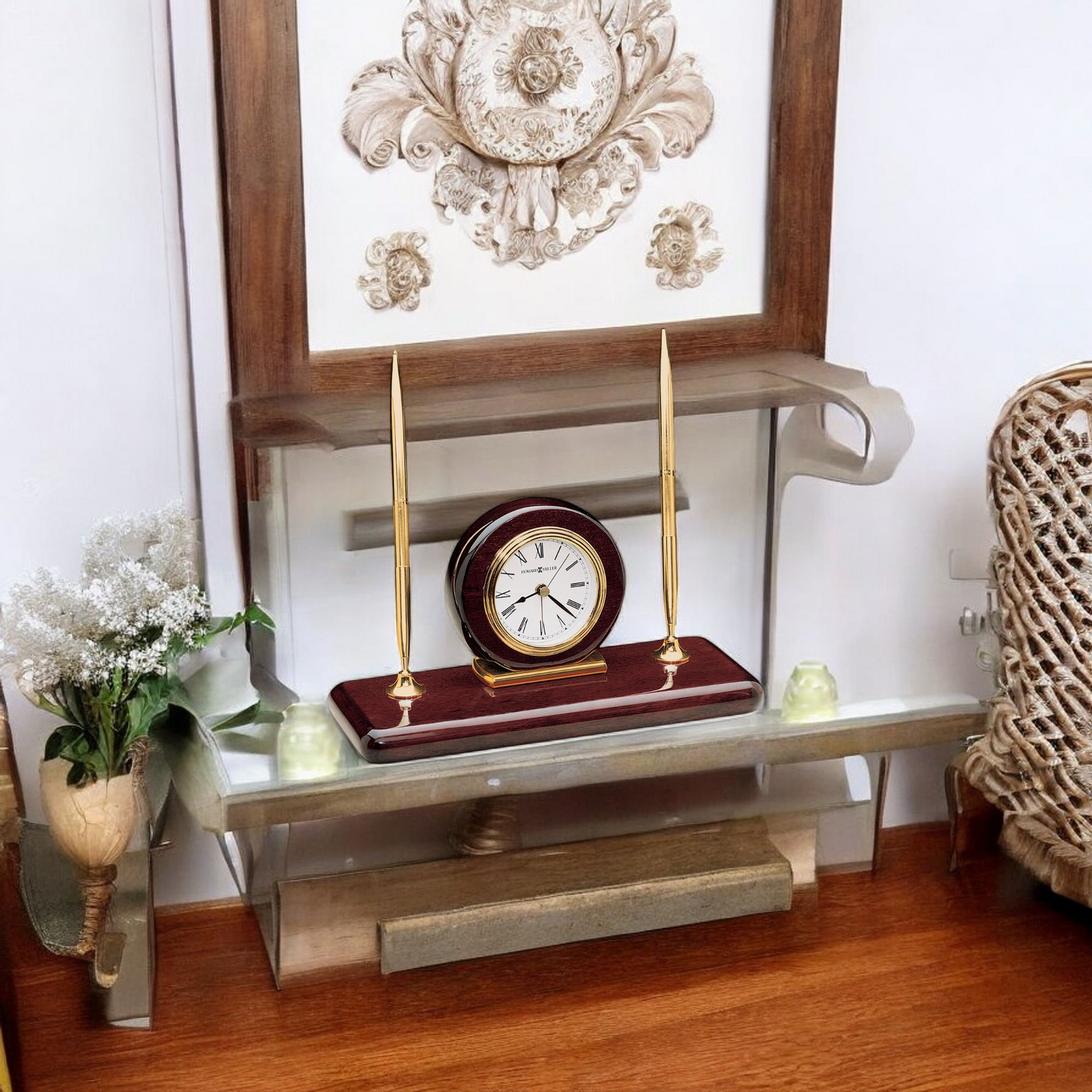A modern shelf displaying a decorative clock, two candle holders, and a small flower arrangement.