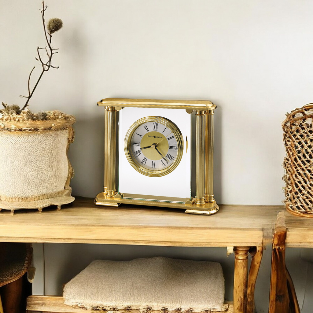A vintage gold clock displayed on a wooden shelf with decorative baskets and a plant.