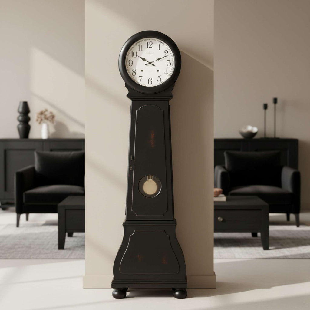 A tall, black grandfather clock against a wall in a modern living room setting.