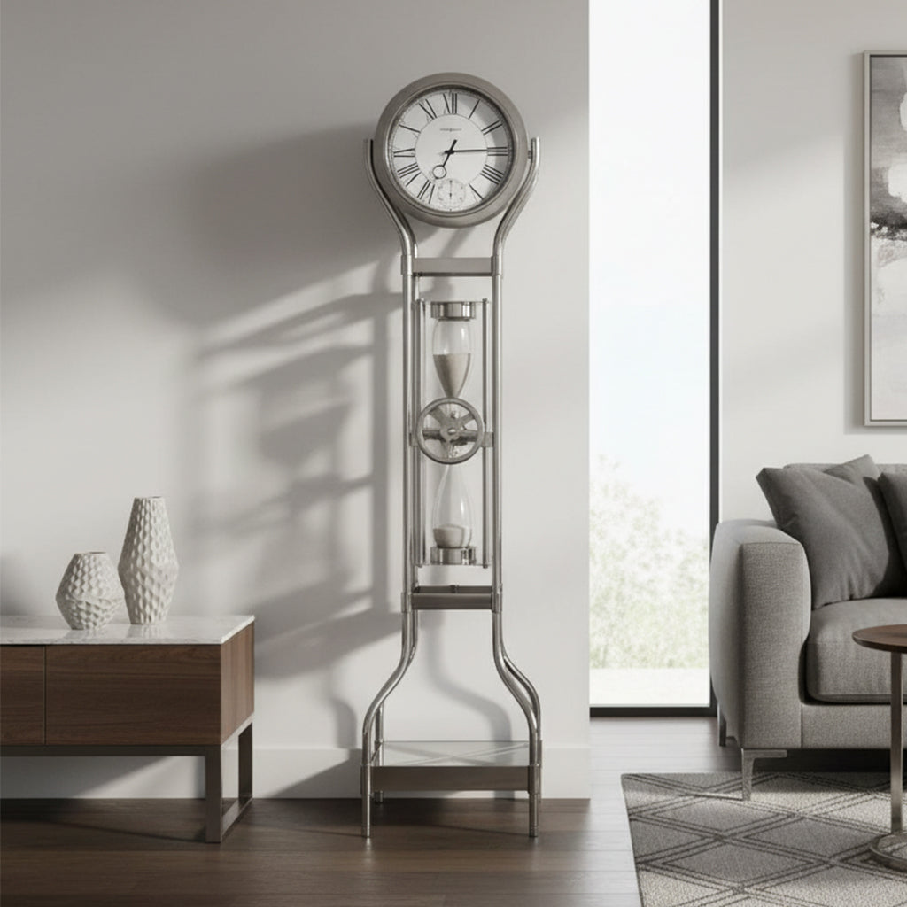 A modern floor clock with a circular face and hourglass design, placed beside a sofa in a bright living room.