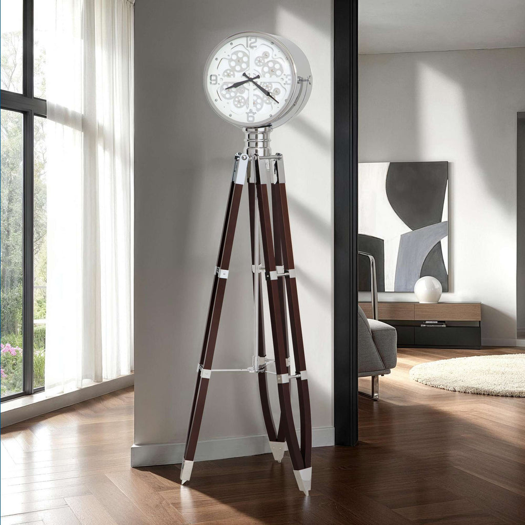 A modern floor clock with a white clock face and wooden tripod legs in a stylish interior setting.