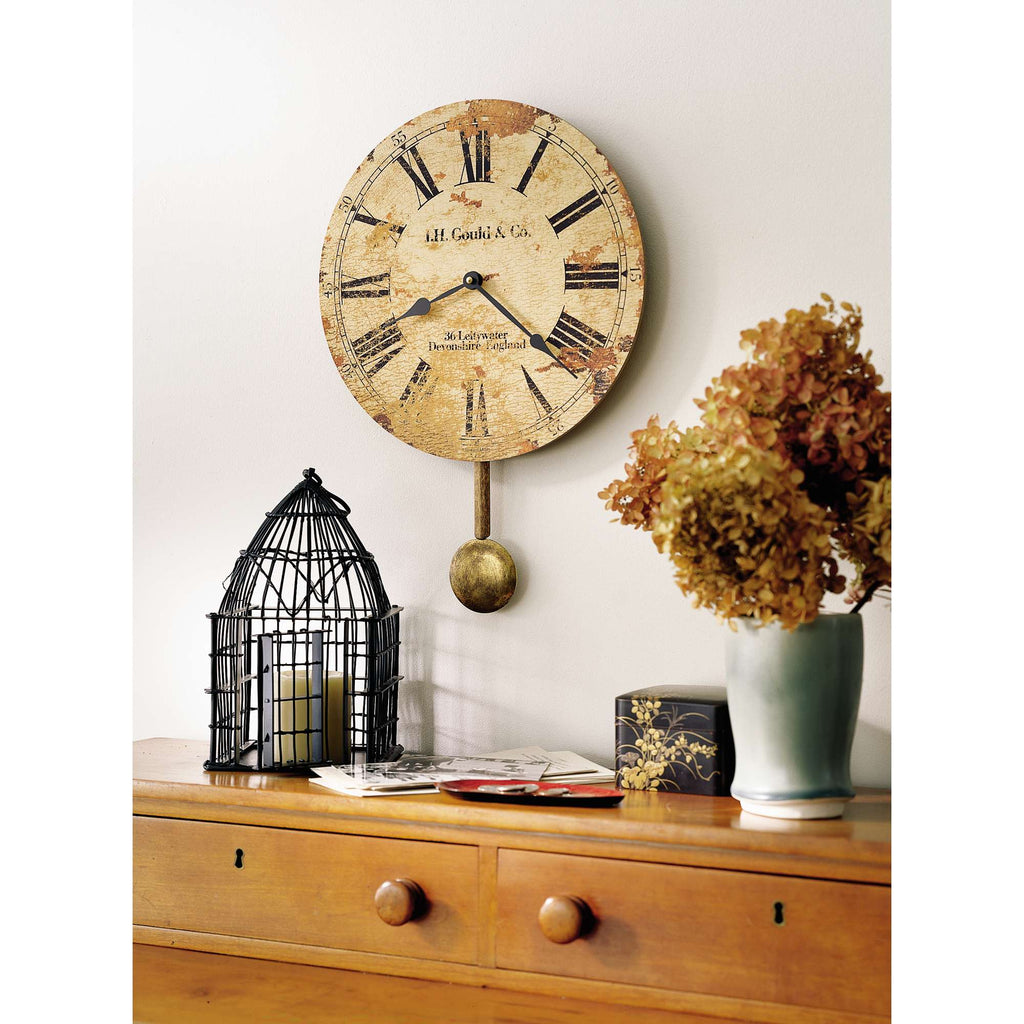 Vintage wall clock with Roman numerals, decorative birdcage, and flowers on a wooden dresser.
