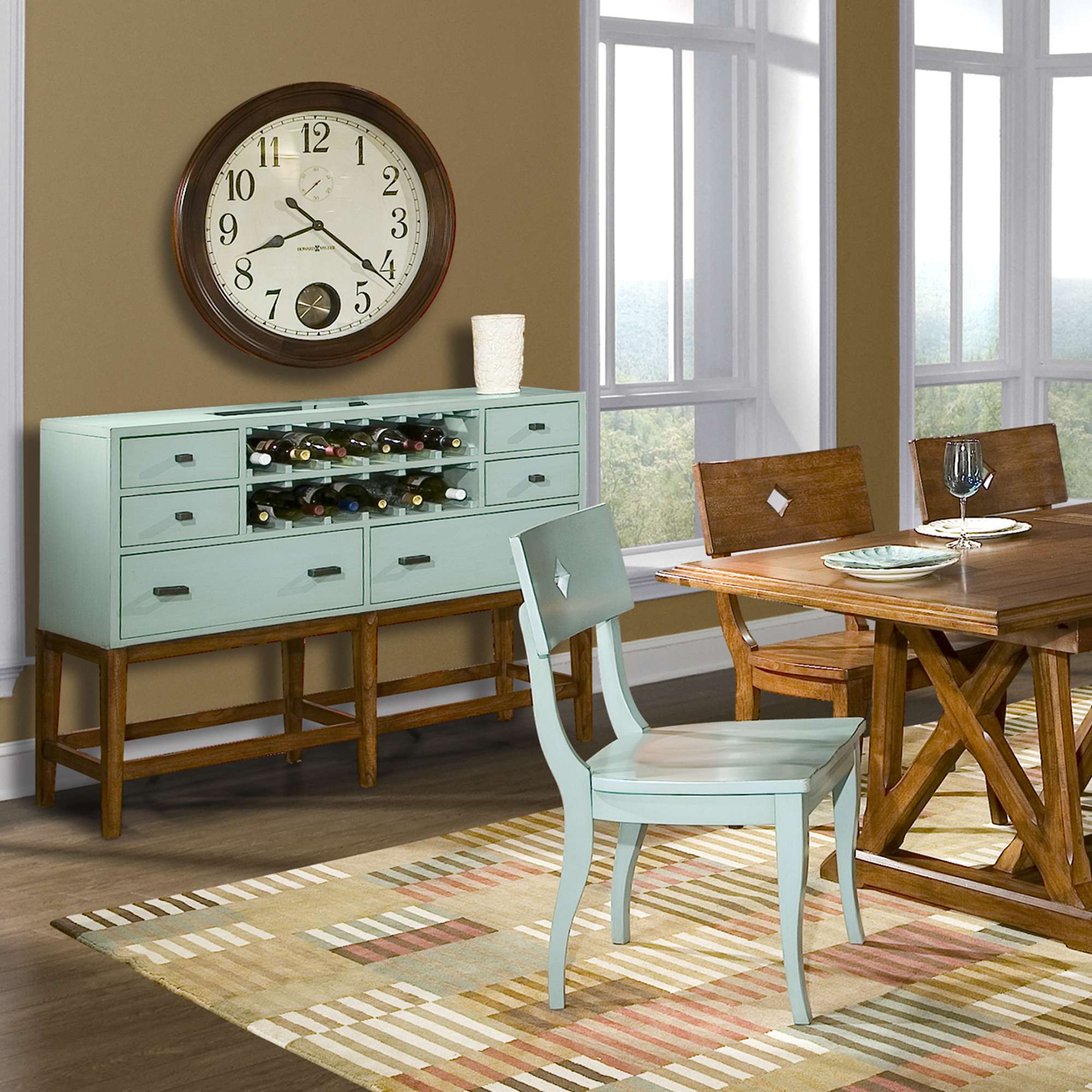 A dining room featuring a wooden dining table, a light blue sideboard with wine storage, and a matching chair, complementing the decor with a patterned rug and a large wall clock.