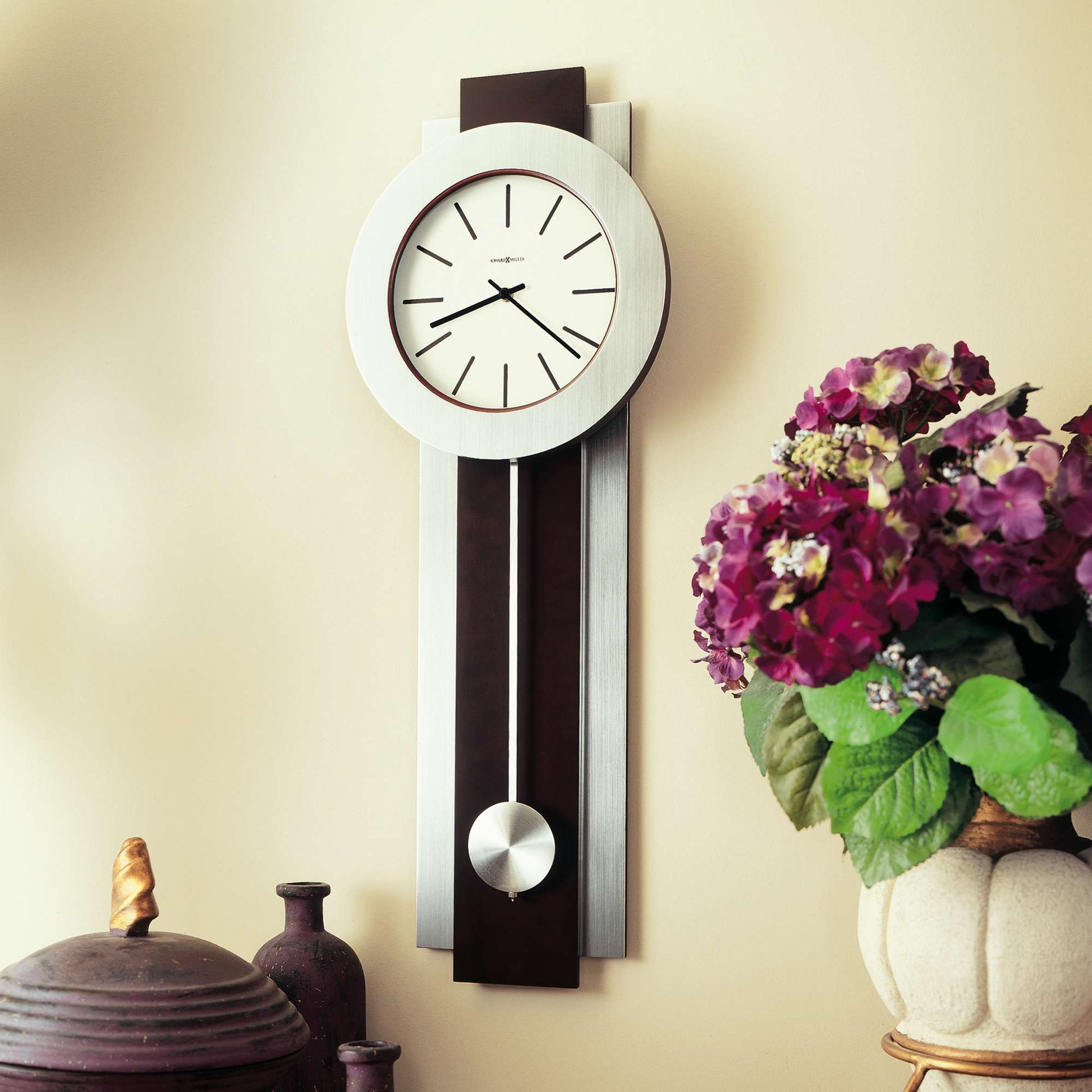 Modern wall clock with floral arrangement and decorative items.