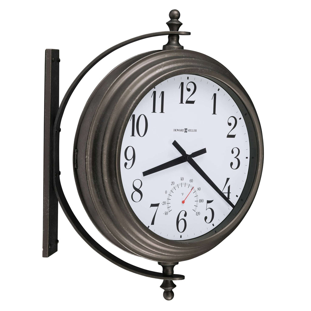A round vintage-style wall clock with a white face and black numerals, mounted on a metal bracket.