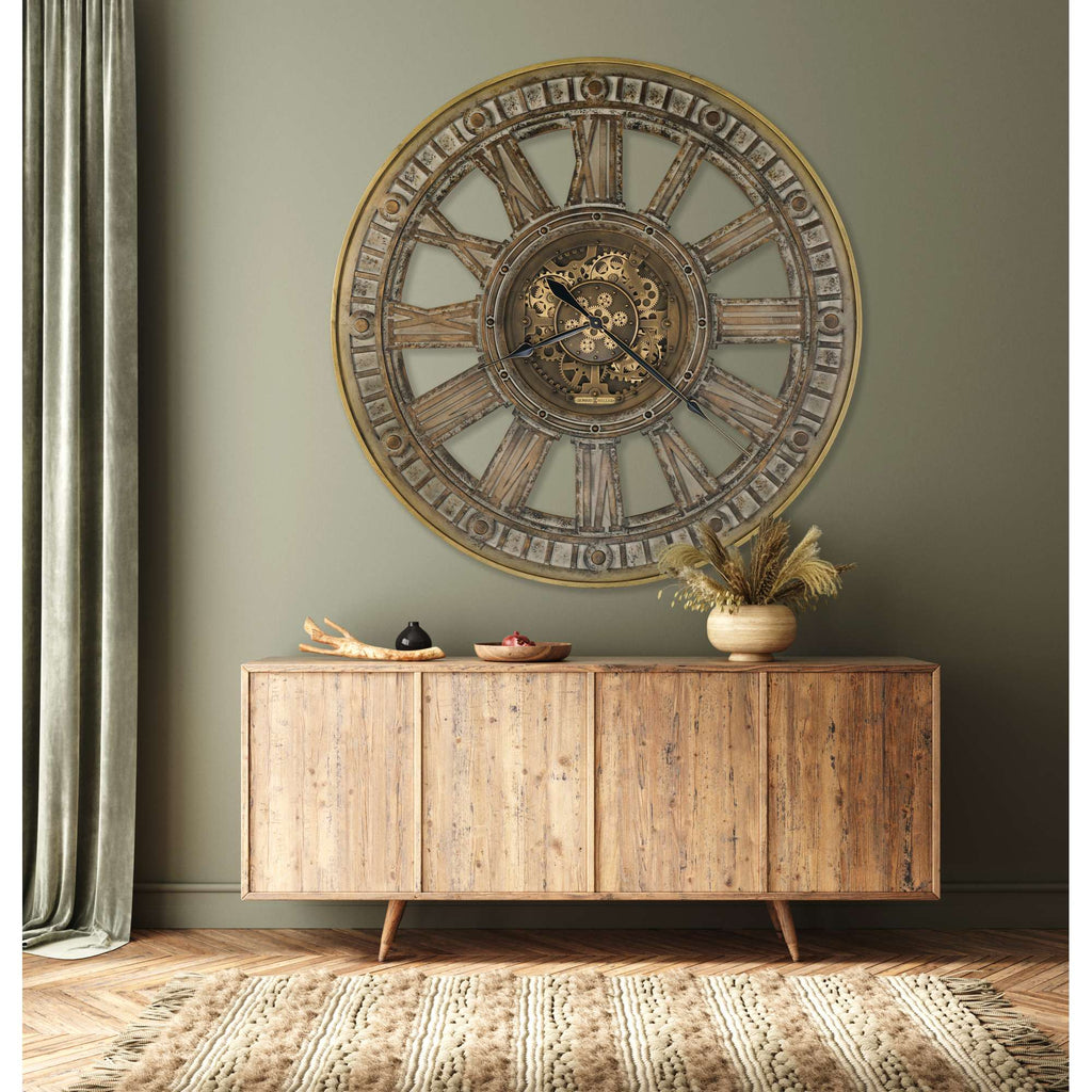 A rustic wooden sideboard with a large round wall clock above it, set against a green wall.