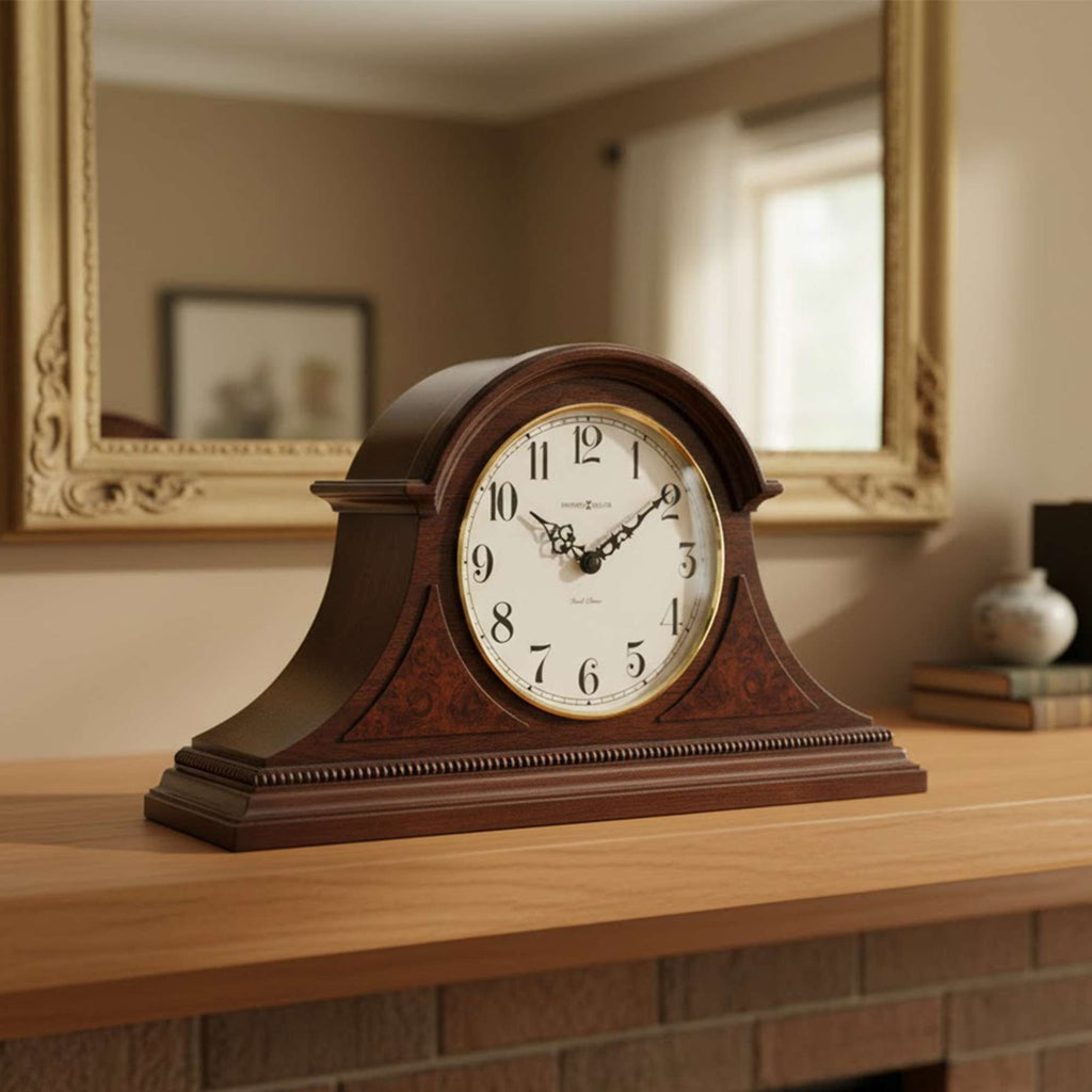 A vintage wooden mantel clock on a table with a mirror in the background.