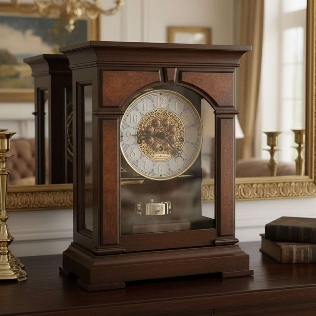 A vintage wooden mantel clock with a glass front display, set on an elegant table next to decorative items.