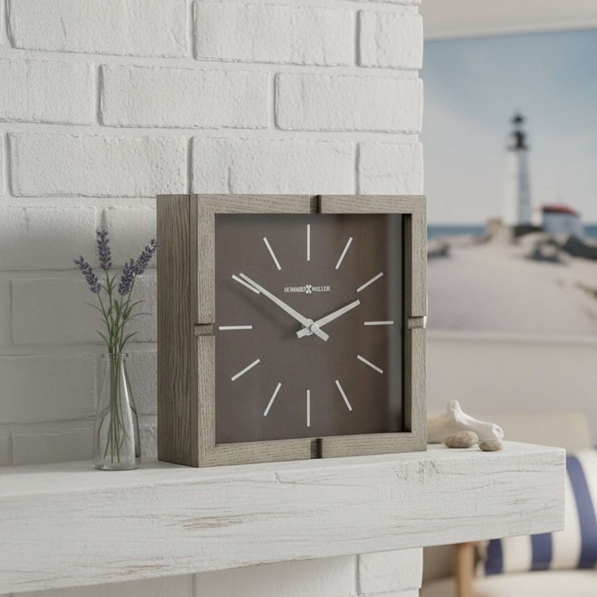 A contemporary square wall clock on a white shelf with lavender and a decorative object.