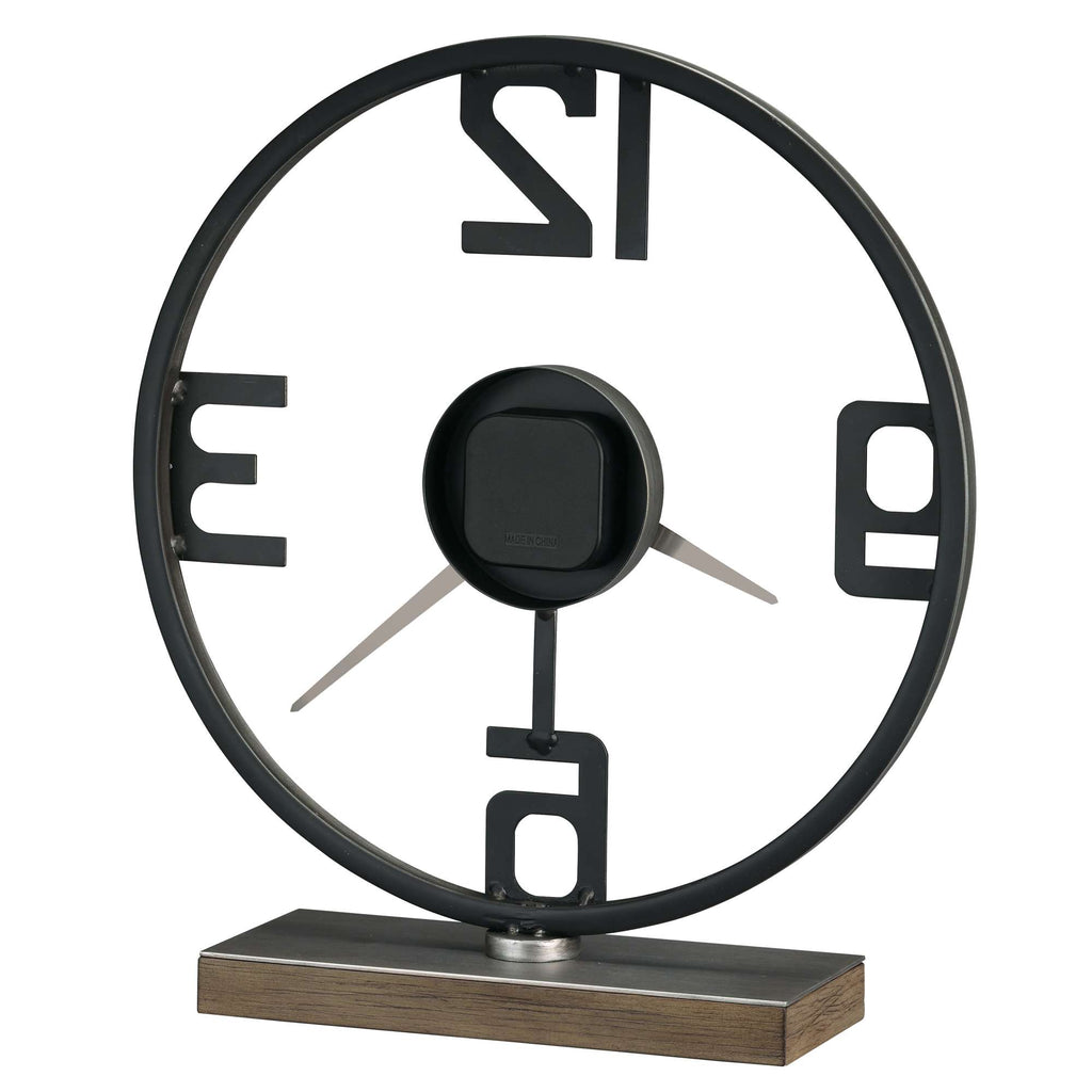 A modern desk clock with a circular design featuring bold numbers 12, 3, 6, and 9, set on a wooden base.