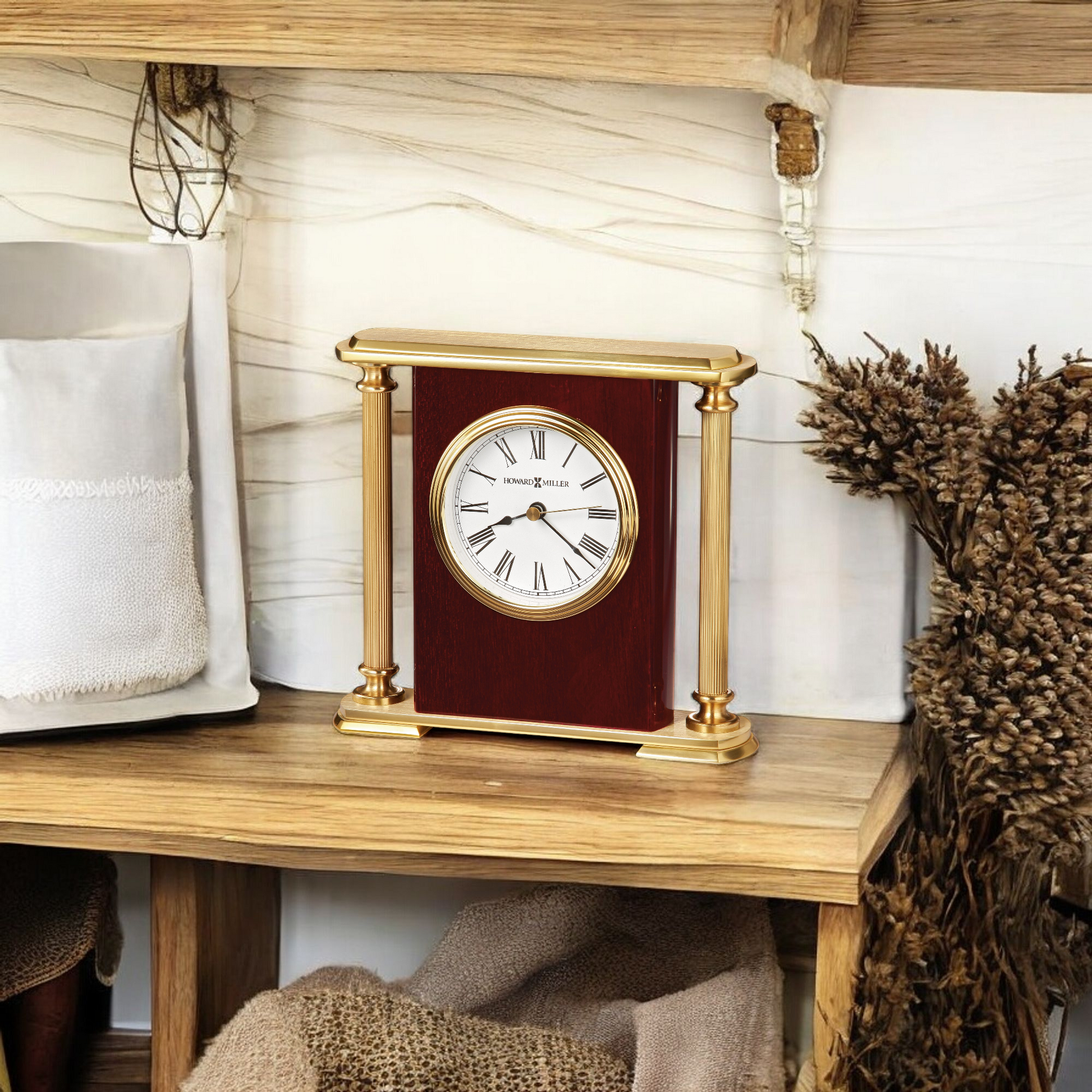 Elegant desk clock displayed on a wooden shelf alongside decorative items.