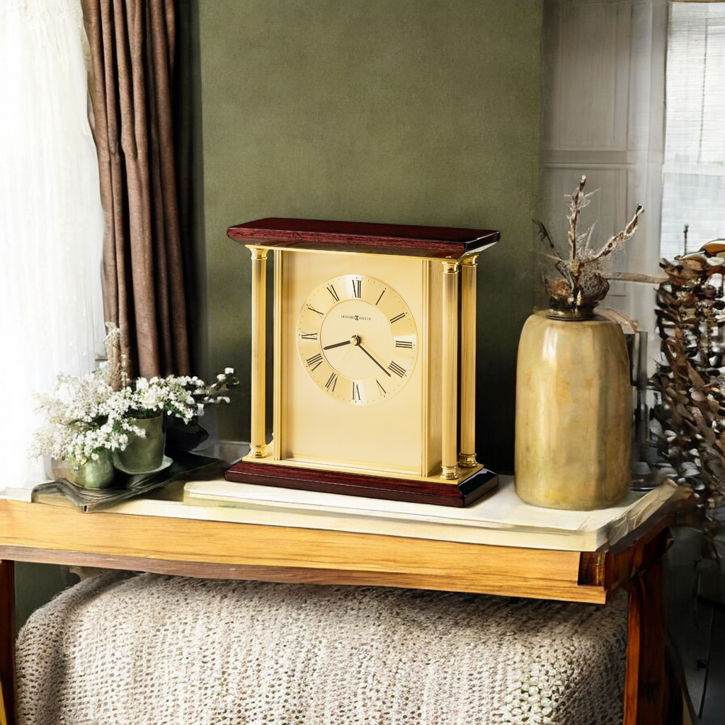 A vintage-style gold and wood clock displayed on a wooden table with decorative elements.