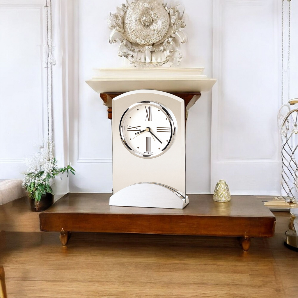 A modern wall clock displayed on a wooden shelf in a stylish interior.