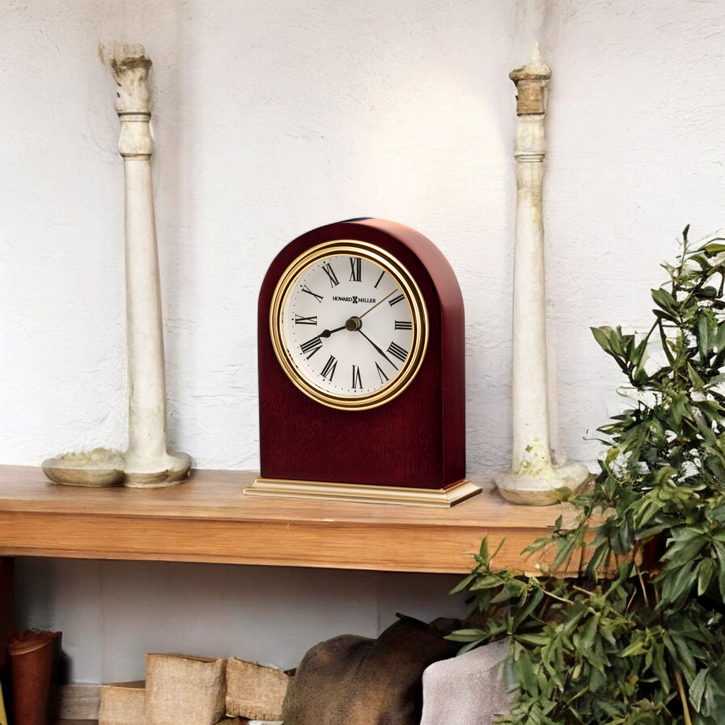A vintage clock on a wooden shelf with decorative elements.