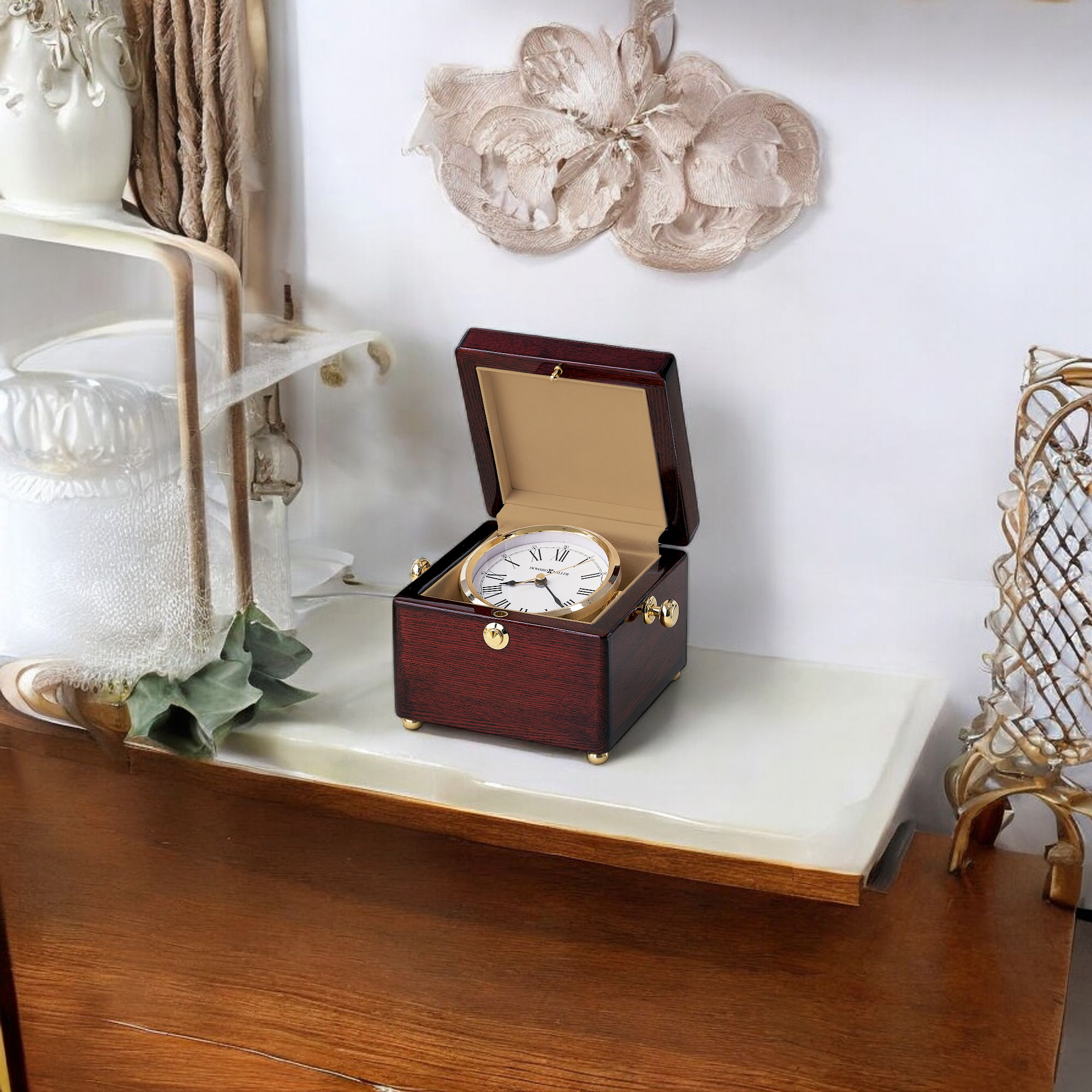 A decorative wooden clock displayed on a shelf with elegant decor.