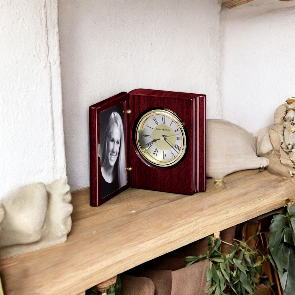 A wooden clock with a photo frame on a shelf.