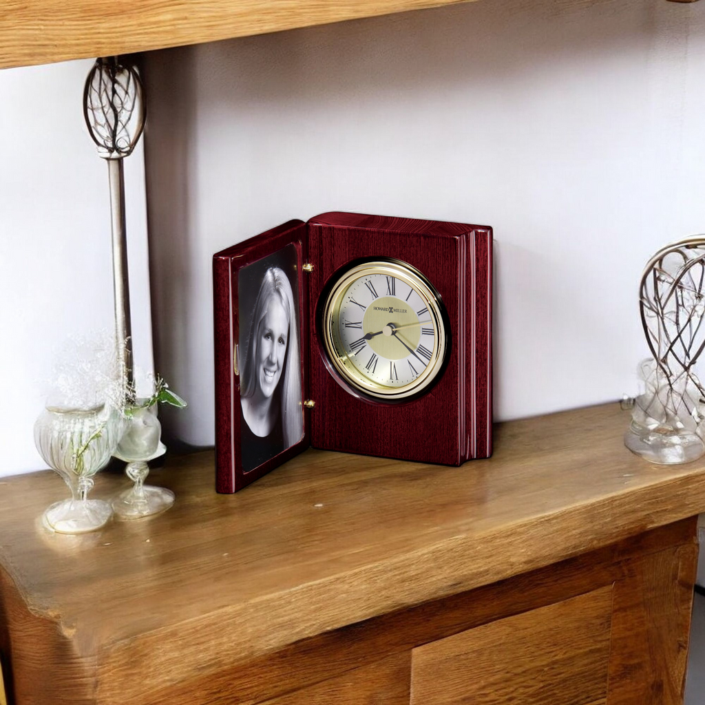 A wooden clock with a photo frame on display atop a shelf.