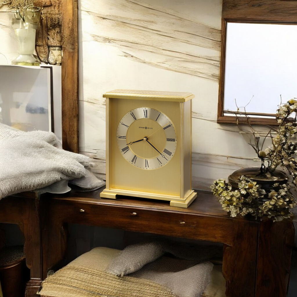 A vintage-style gold clock on a wooden table with cozy textiles and decorative items.