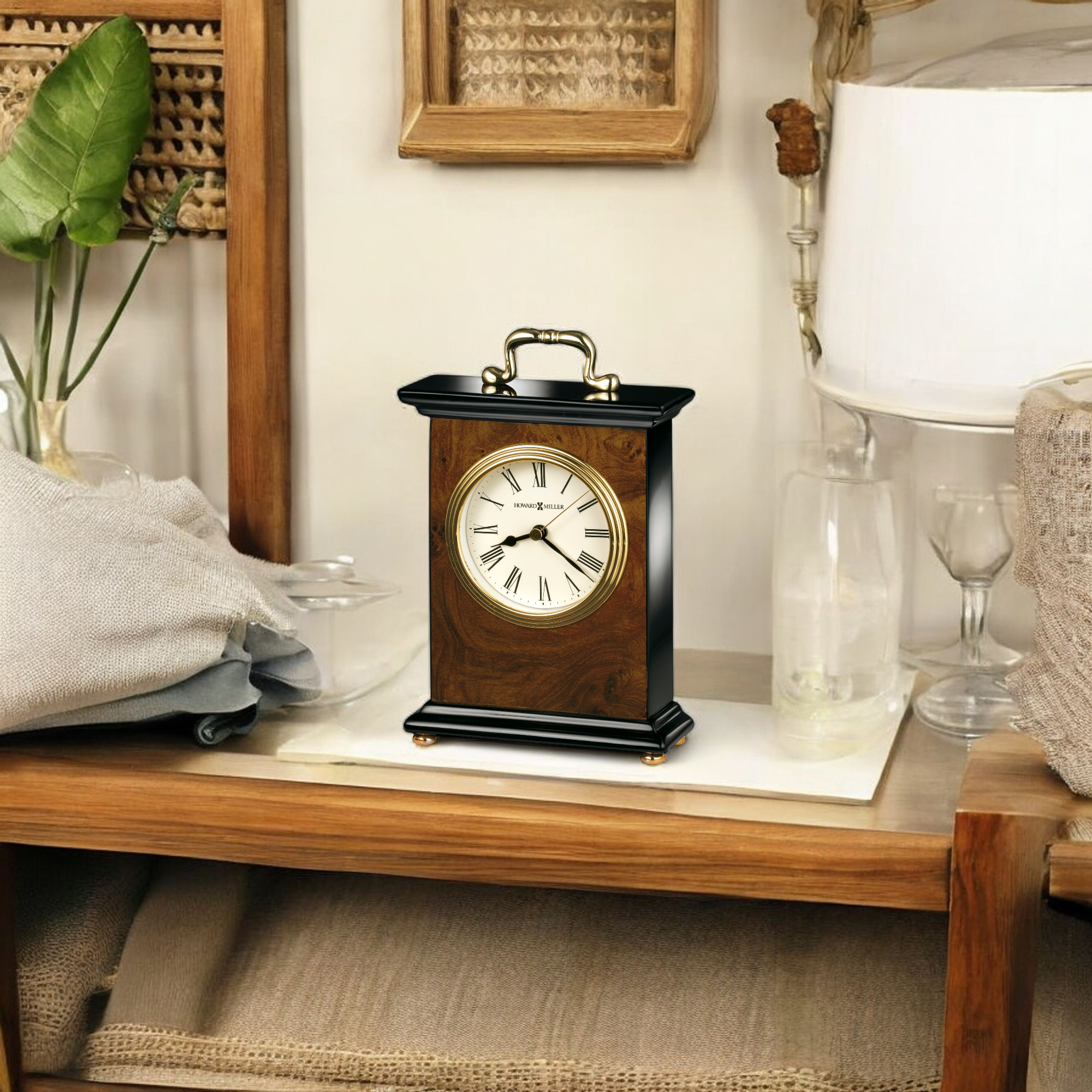 A vintage-style clock on a wooden table, surrounded by decorative items and a blanket.