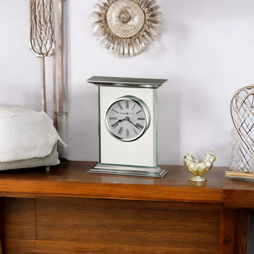 A stylish table clock on a wooden side table with decorative items.