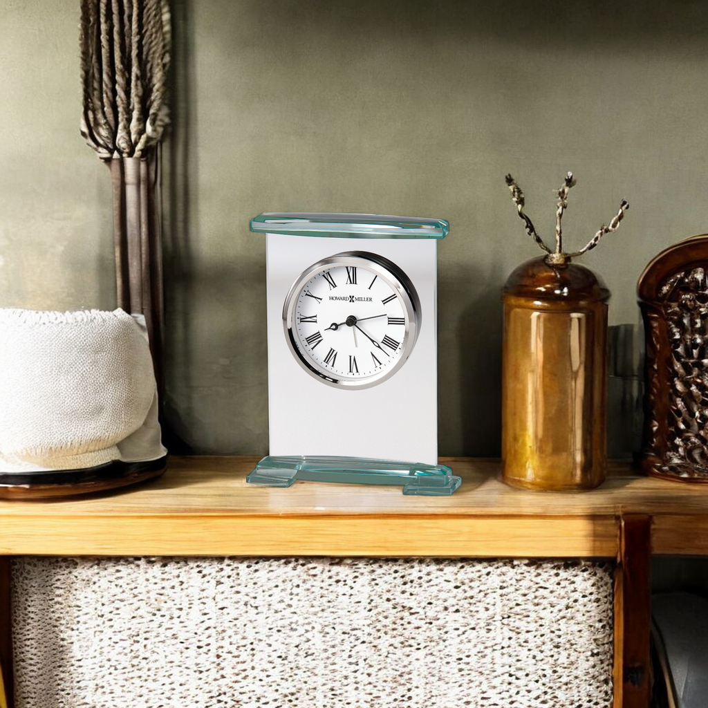 A modern desk clock displayed on a wooden shelf with decorative items.