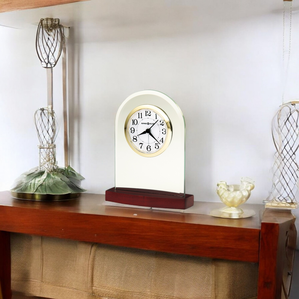 A decorative clock displayed on a wooden shelf with other decorative items.