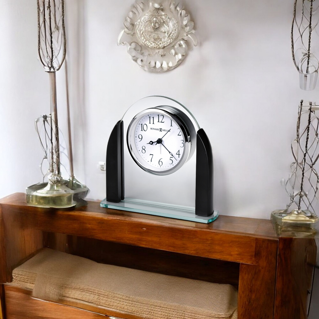 A stylish wall clock on a wooden shelf with decorative objects and a neutral background.