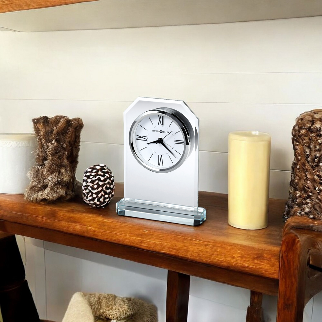 A decorative clock displayed on a wooden shelf, surrounded by various decorative items.
