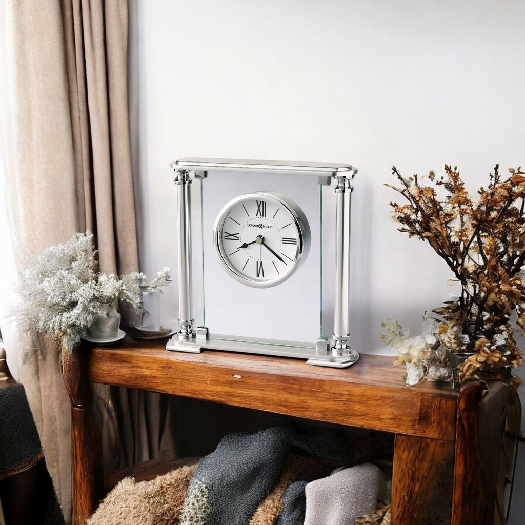 Elegant silver clock displayed on a wooden table with decorative plants