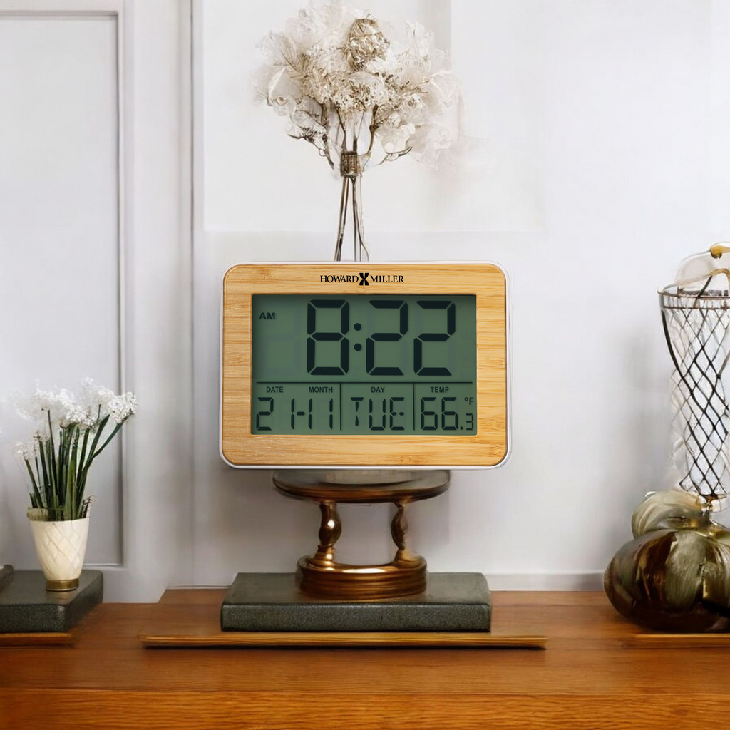 Digital clock displaying 8:22 AM on a wooden table with decorative flowers and items.