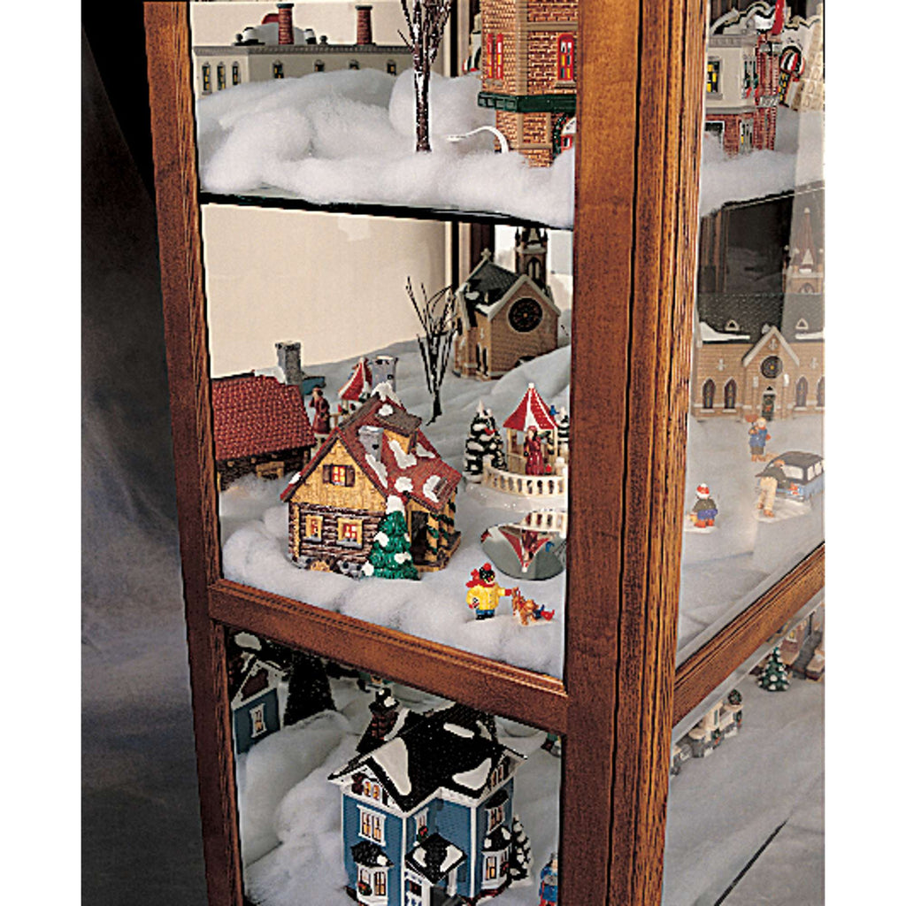 A display case filled with miniature snowy village scenes and holiday decorations.