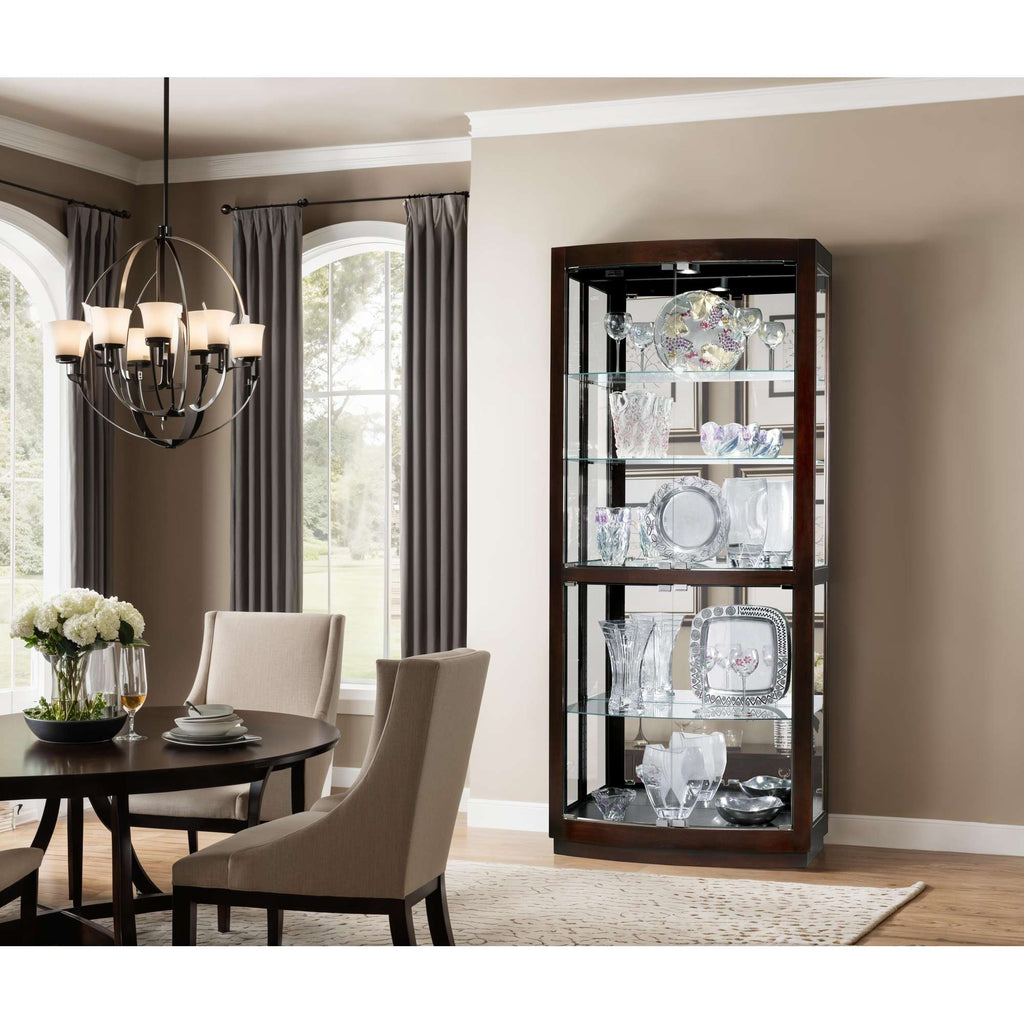 A modern display cabinet showcasing elegant glassware and decorative plates next to a dining area.
