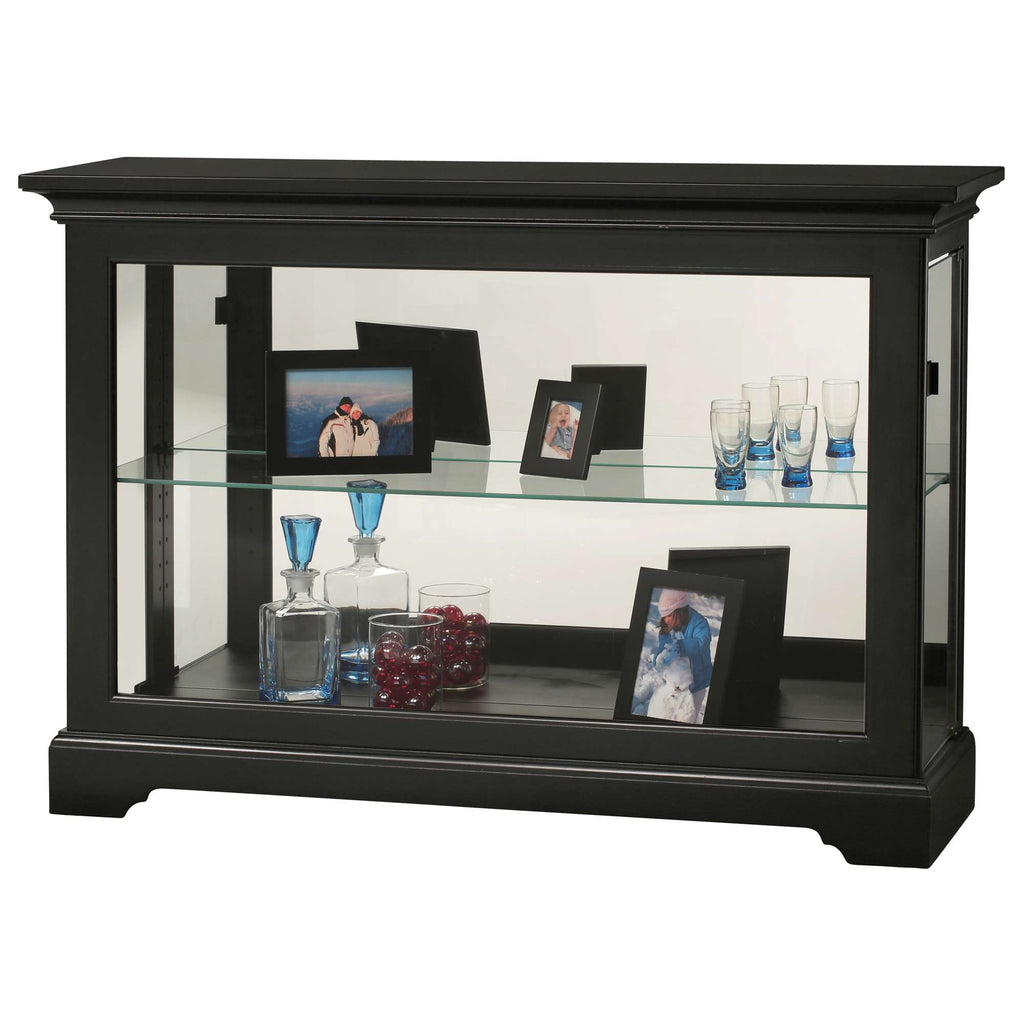 Black display cabinet with glass shelves holding photos and decorative items