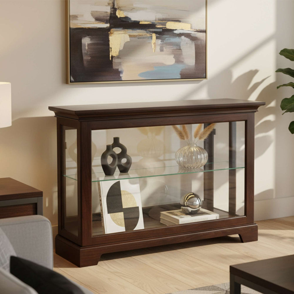 A stylish wooden display cabinet with glass shelves, showcasing decorative items, in a modern living room.