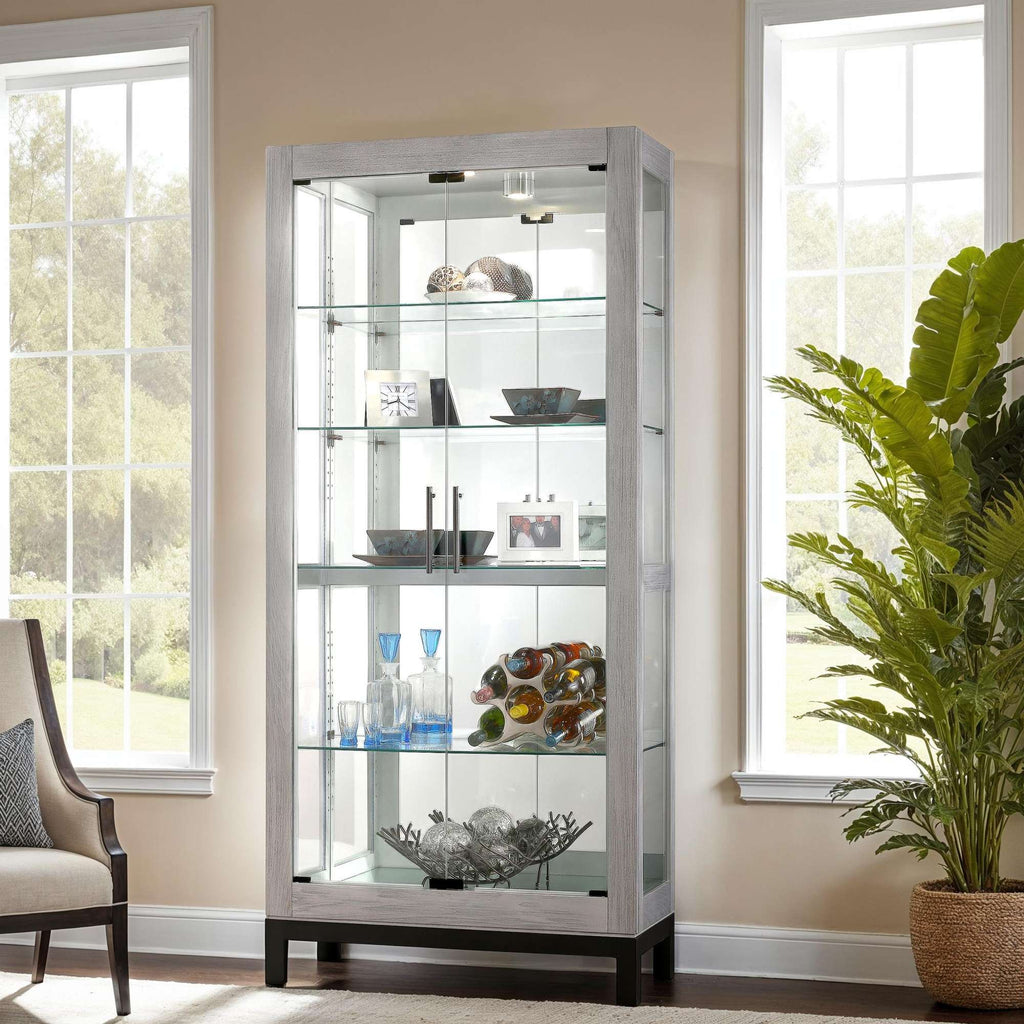 A modern display cabinet showcasing decorative items, with large windows allowing natural light to illuminate the scene.
