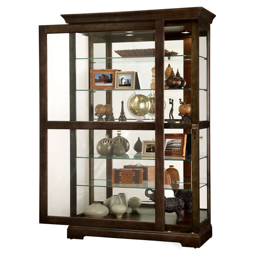 A wooden display cabinet with glass shelves showcasing various decorative items and photo frames.