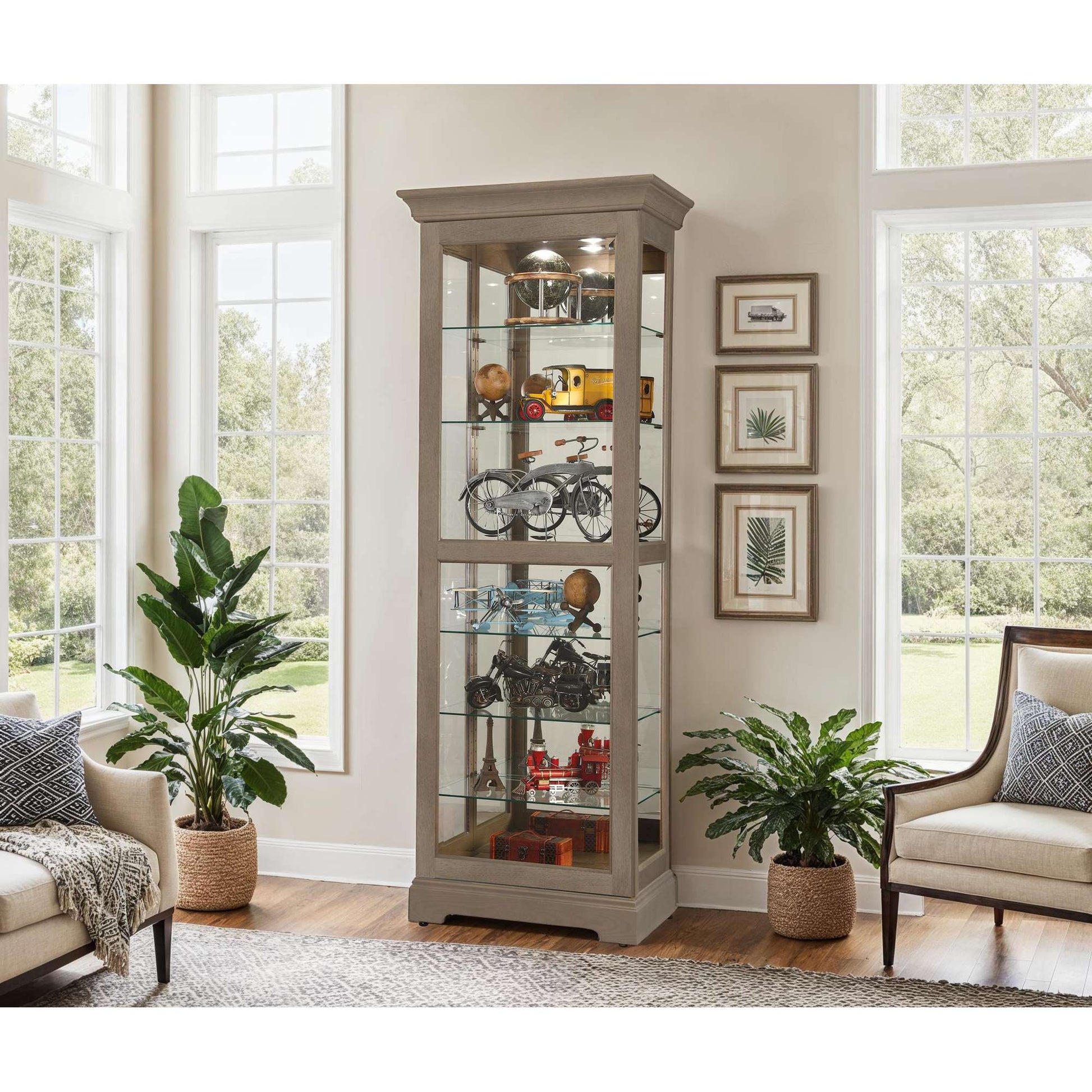 A tall display cabinet showcasing various collectibles, surrounded by indoor plants and natural light from large windows.