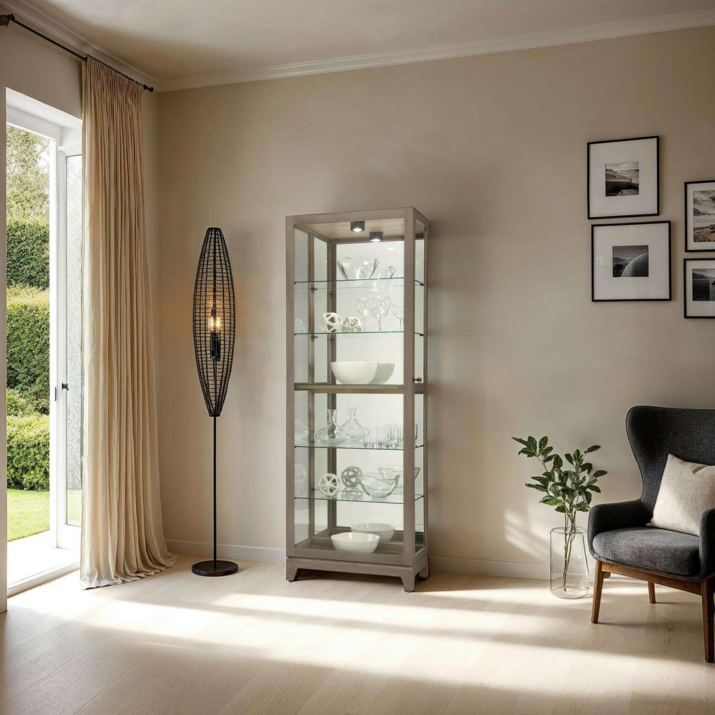 A stylish living room featuring a glass display cabinet, a modern floor lamp, and a comfortable chair.