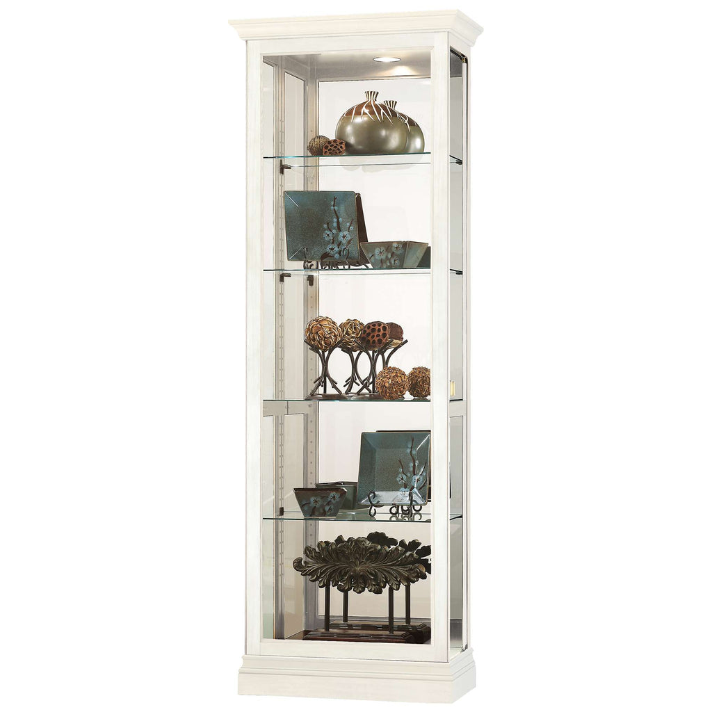 A tall, white display cabinet with glass shelves holding decorative items.