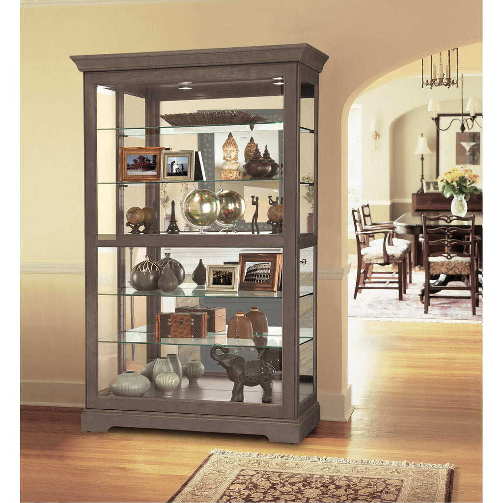 A stylish glass display cabinet featuring decorative items and photographs in a well-lit living space.