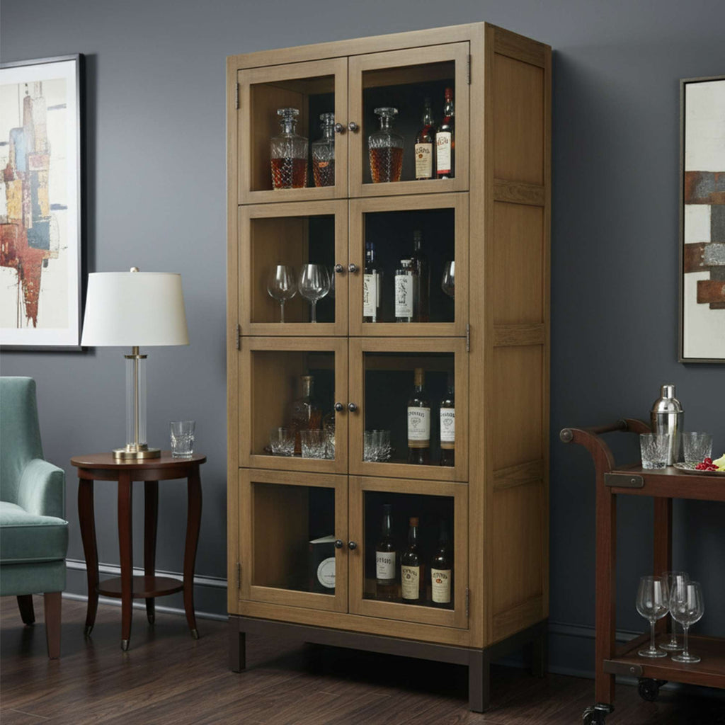 A wooden display cabinet with glass doors, showcasing various bottles and glassware, set in a stylish living room.
